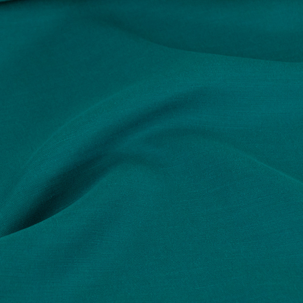 mirco photo of sea green coloured drapey lyocell tencel ripples over surface