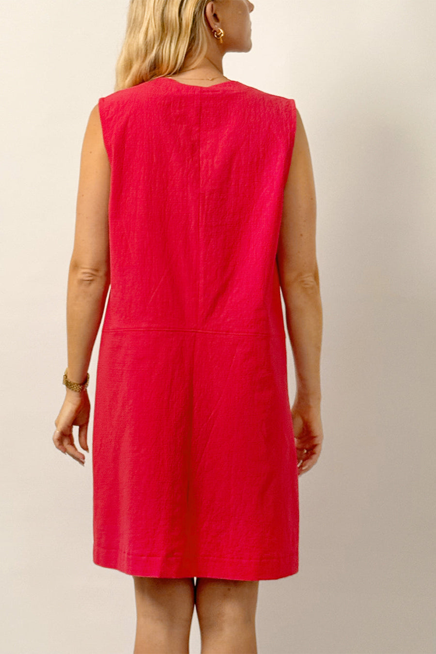 Red dress worn by a person on a plain background