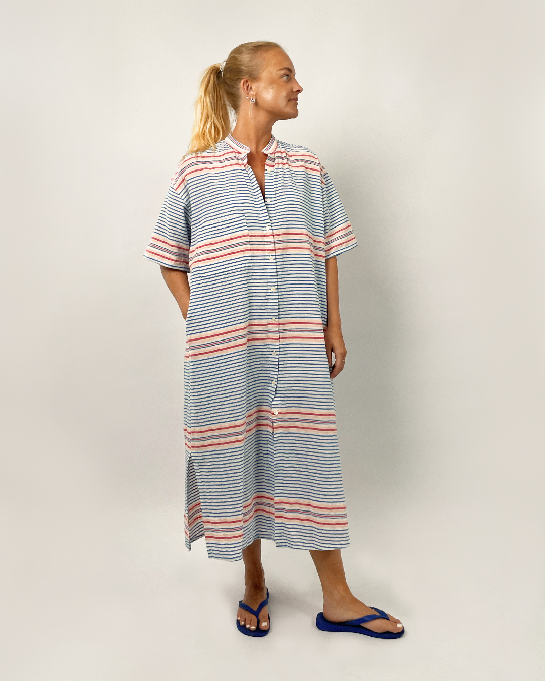 Woman wearing a striped dress on a plain background